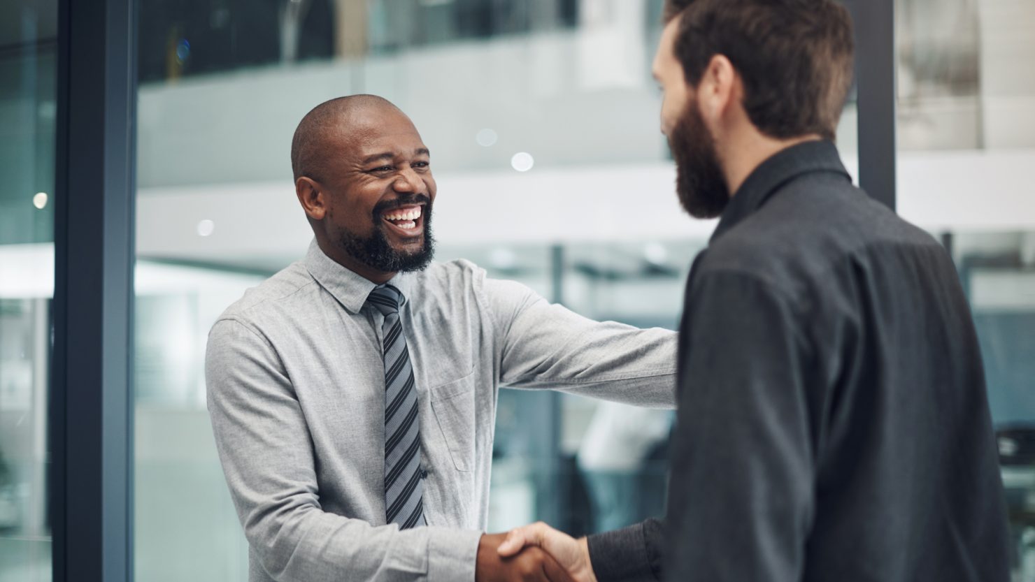 Two men shaking hands excited about promotion