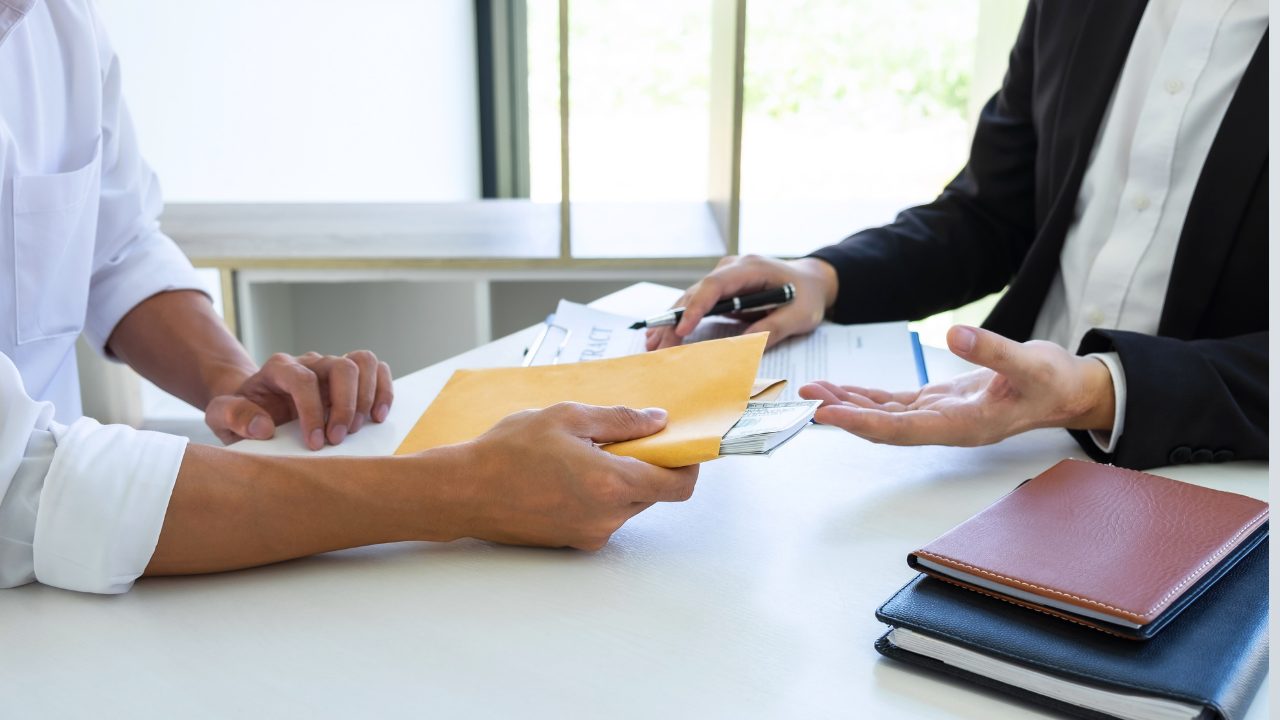 Person signing a contract and being given cash