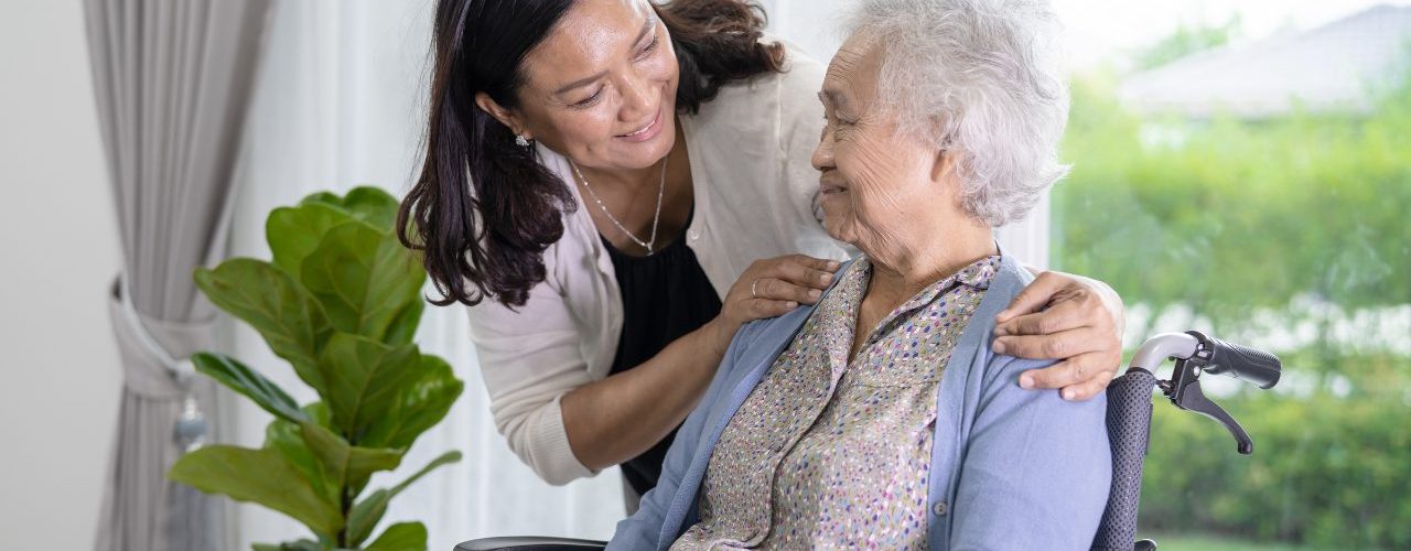 younger woman caregiving for a senior woman in a wheelchair